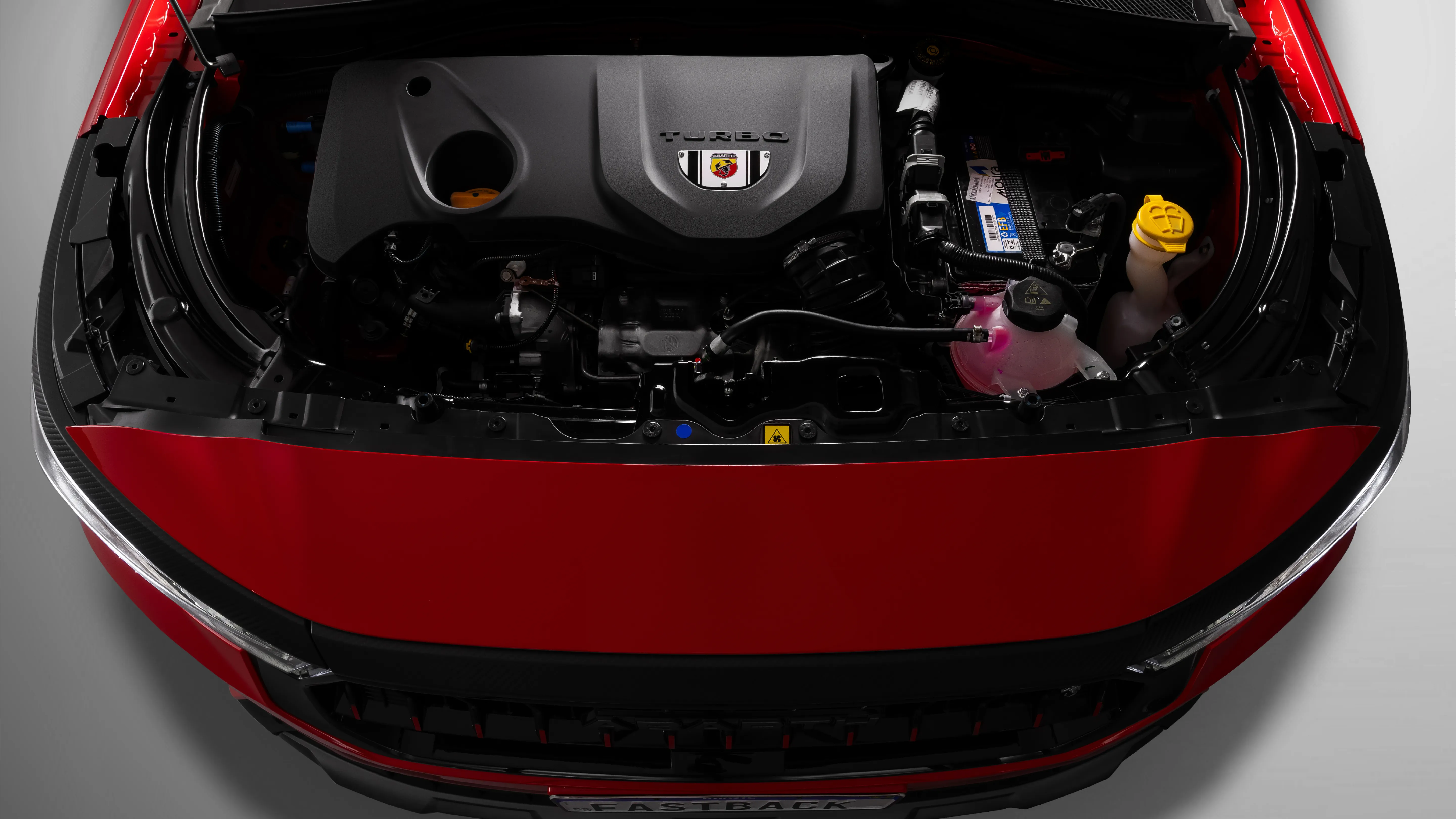 Capô aberto de um Fastback Abarth na cor vermelha, com destaque para motor T270, de 185 cv de potência e 270 Nm de torque.