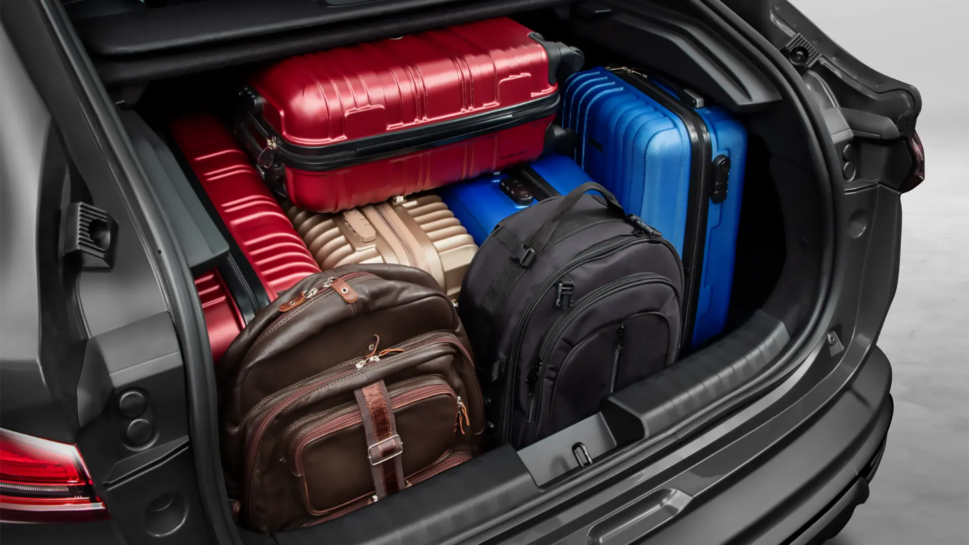 Zoom no porta-malas do Fiat Fastback aberto, com diversas malas e mochilas ocupando o espaço.​