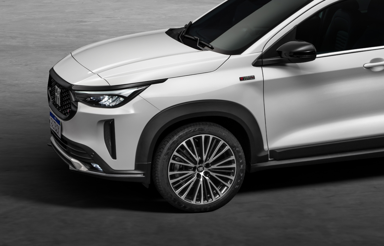 Vista lateral dianteira, com destaque para rodas aro 18 do Fiat Fastback na cor branca